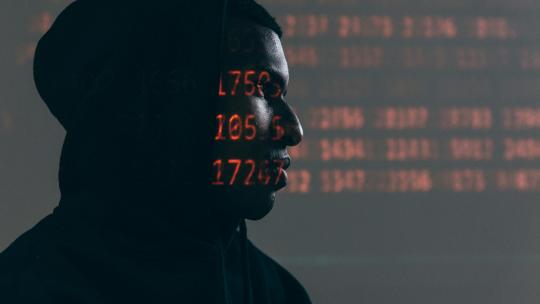 ciberseguridad-en-colombia persona-con-capucha-proyectada-con-codigos-binarios-como-representacion-de-la-ciberseguridad-en-colombia